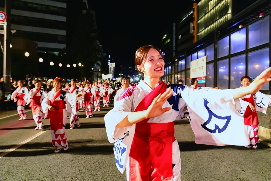 夜の通りで浴衣姿で踊る人たち